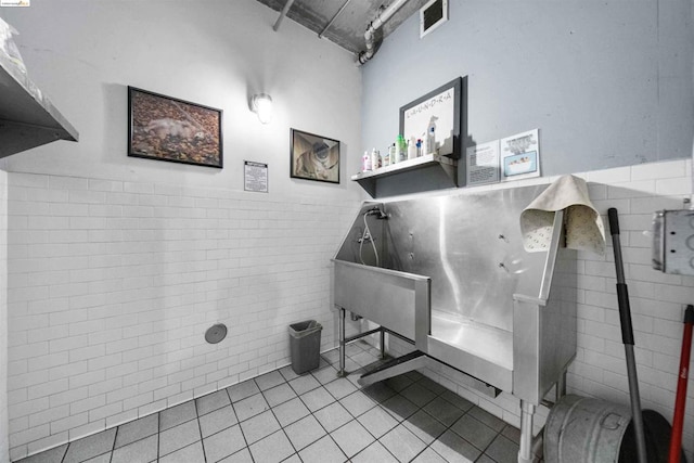 miscellaneous room featuring tile walls and light tile patterned floors