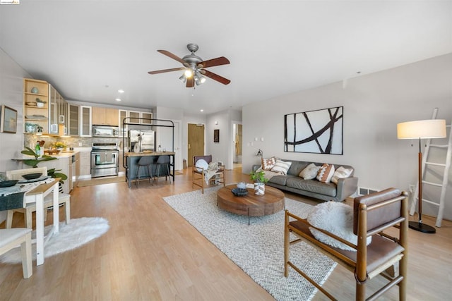 living room with light wood-type flooring and ceiling fan