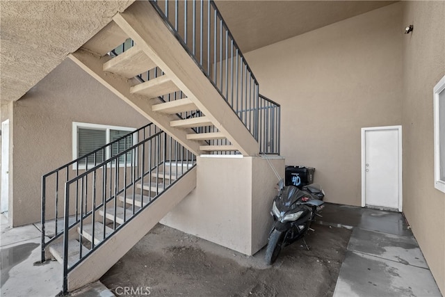 staircase with concrete flooring and a towering ceiling