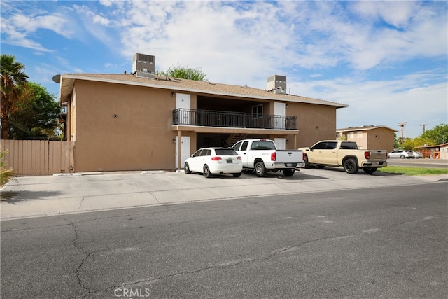 view of front of home featuring a balcony and cooling unit