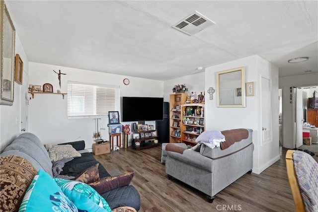 living room featuring a textured ceiling and dark hardwood / wood-style flooring