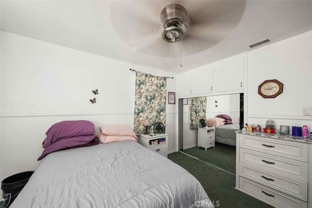 bedroom with dark carpet, a closet, and ceiling fan