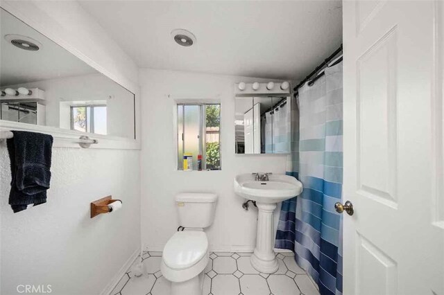 bathroom with plenty of natural light and toilet