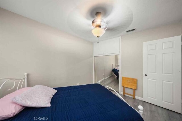 bedroom with ceiling fan, hardwood / wood-style floors, and a closet