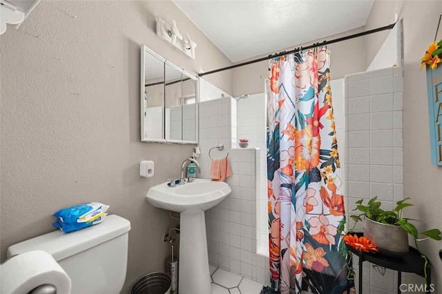 full bathroom featuring sink, toilet, tile patterned flooring, and shower / bath combo