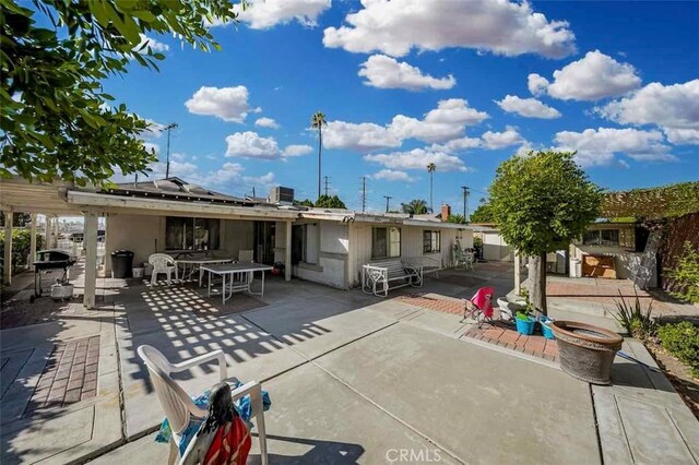 back of property with cooling unit, a patio, and solar panels