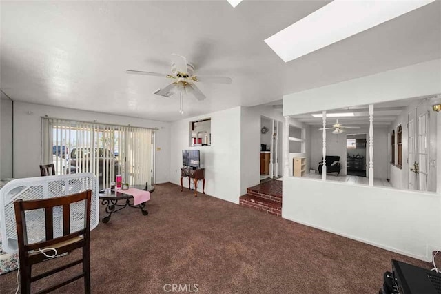 living room with ceiling fan, a skylight, and carpet floors