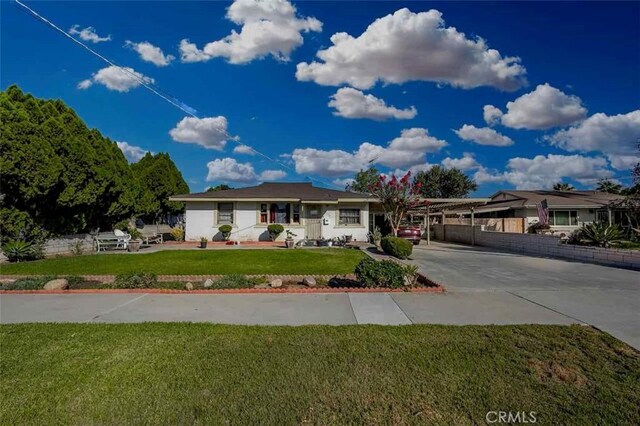 ranch-style home featuring a carport and a front lawn