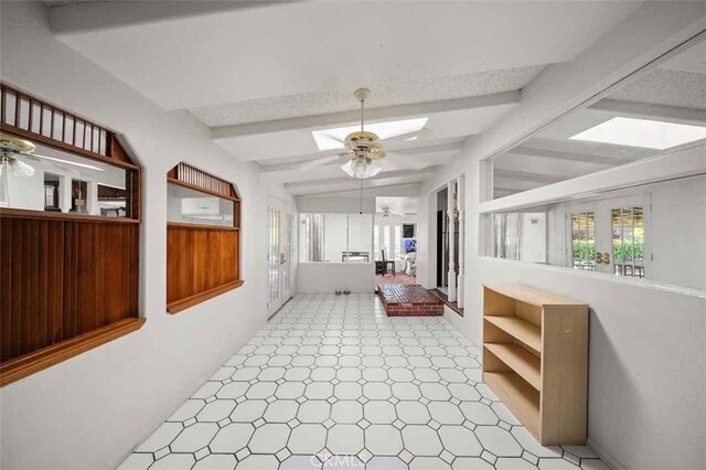 hallway with lofted ceiling with skylight