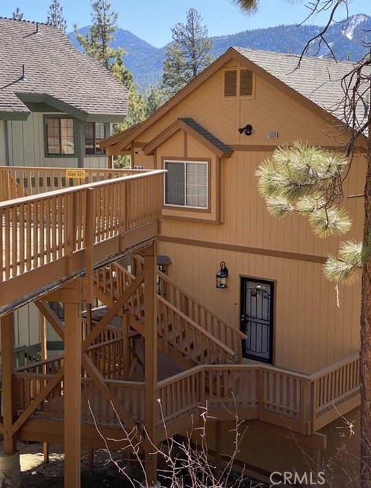 rear view of house featuring a deck with mountain view