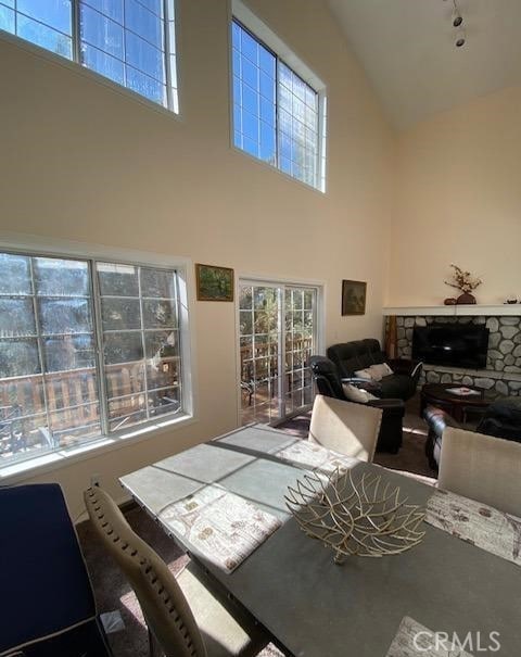 living room with a fireplace and a towering ceiling