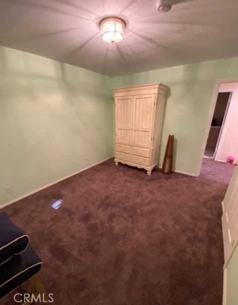 unfurnished bedroom with dark colored carpet