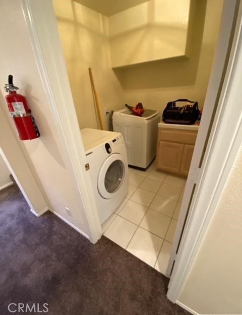 laundry room with washer and clothes dryer and light tile patterned floors