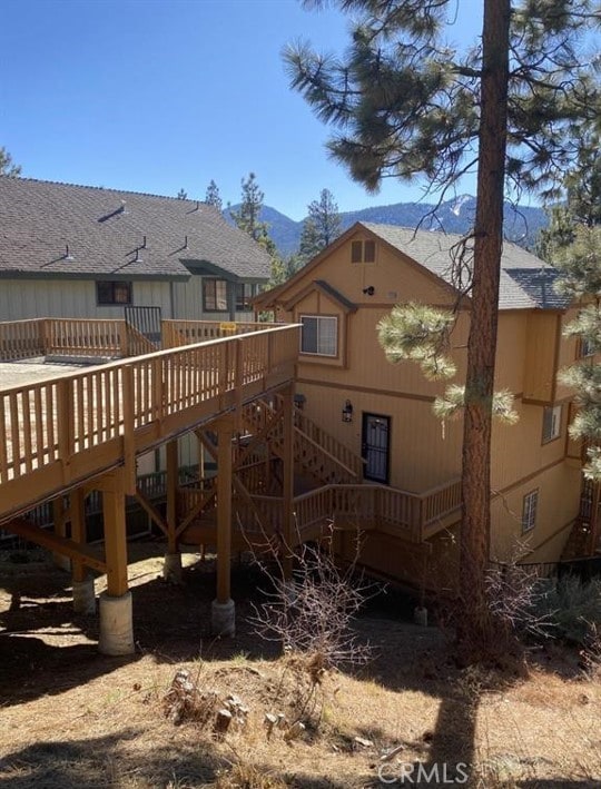 rear view of property with a deck with mountain view