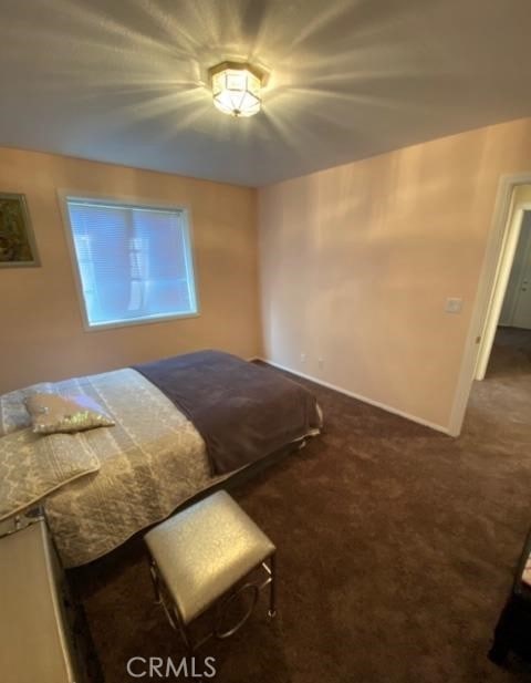 unfurnished bedroom with dark colored carpet