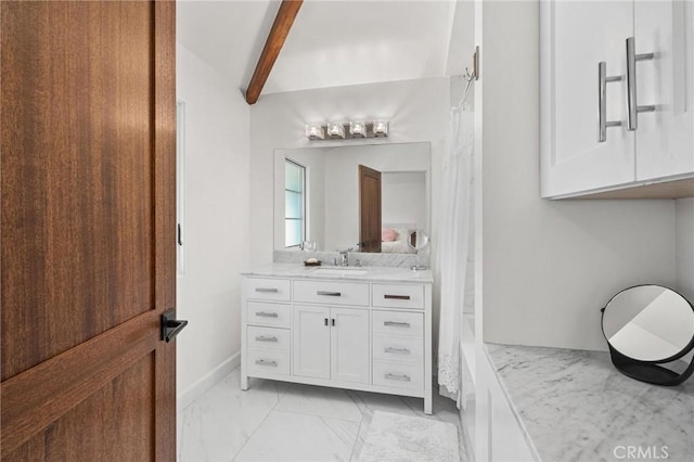 bathroom featuring vaulted ceiling with beams and vanity