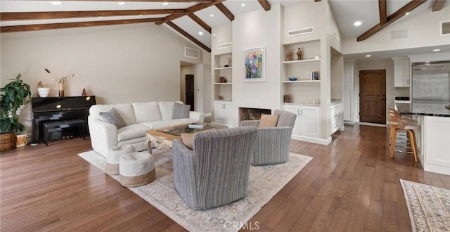 living room with built in shelves, beam ceiling, dark wood-type flooring, and high vaulted ceiling