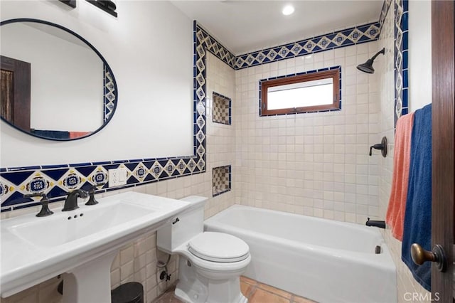 full bathroom with tasteful backsplash, tile patterned floors, toilet, tile walls, and tiled shower / bath