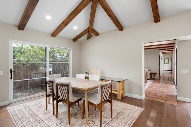 dining room with lofted ceiling with beams and dark hardwood / wood-style flooring