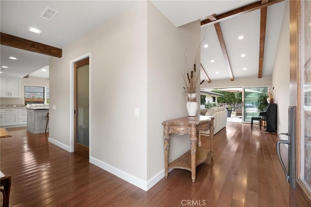 corridor featuring beamed ceiling and dark hardwood / wood-style floors