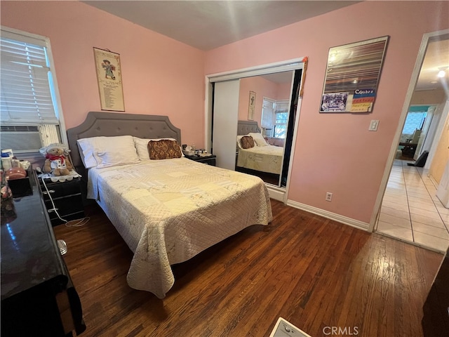 bedroom with a closet, dark hardwood / wood-style flooring, and cooling unit