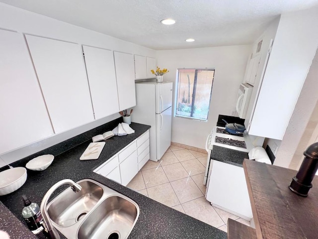 kitchen with light tile patterned flooring, white appliances, white cabinetry, and sink