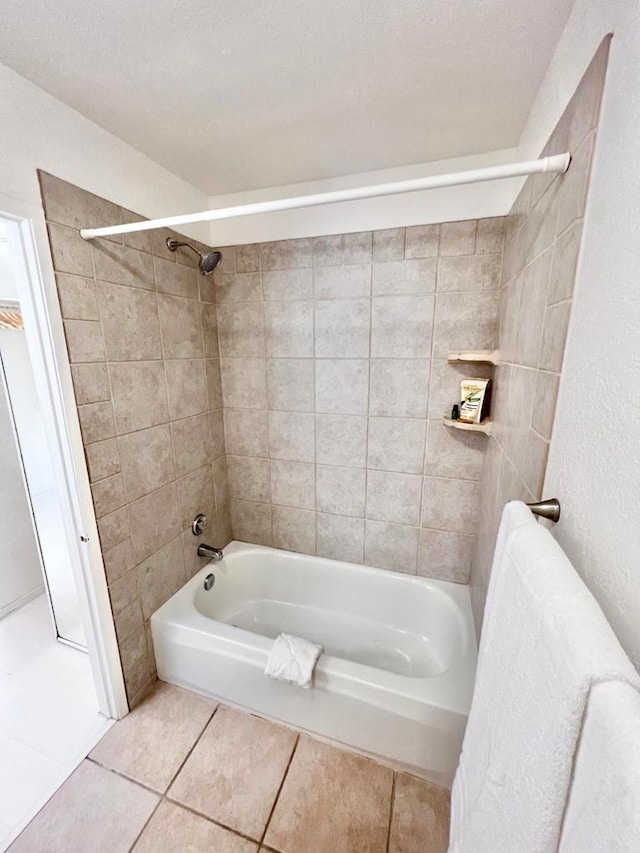 bathroom with tile patterned flooring, tiled shower / bath combo, and a textured ceiling