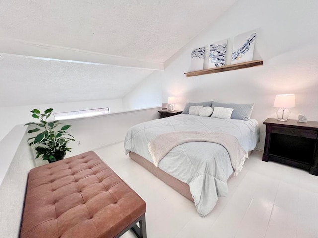 bedroom featuring vaulted ceiling and a textured ceiling