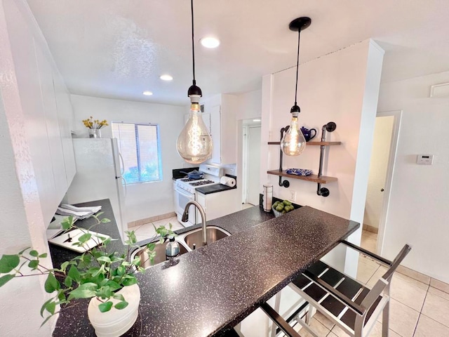 kitchen featuring pendant lighting, white appliances, sink, and light tile patterned floors