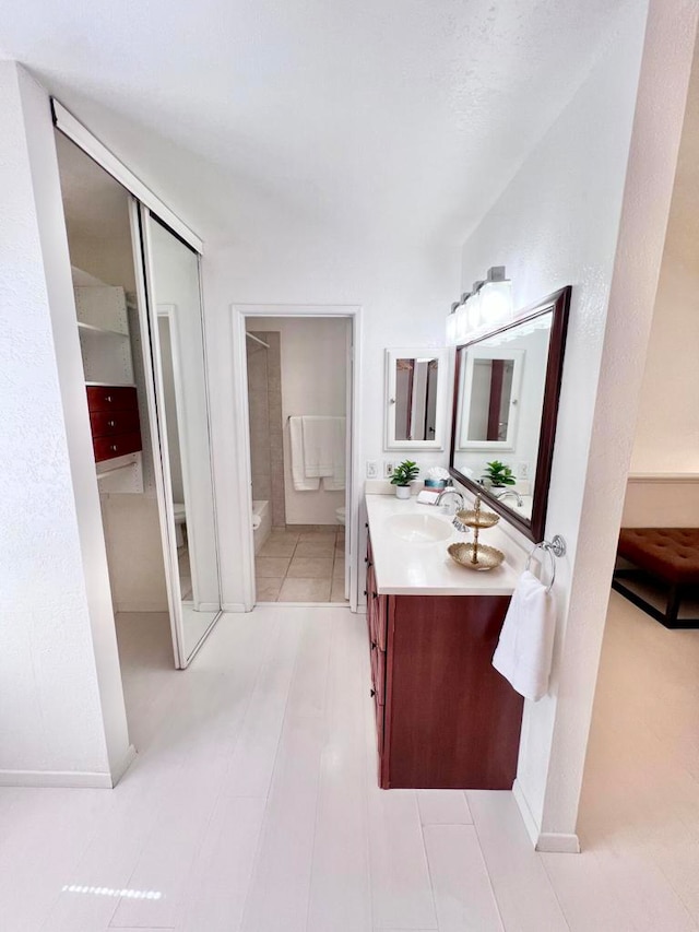 bathroom featuring vanity, tile patterned flooring, and toilet