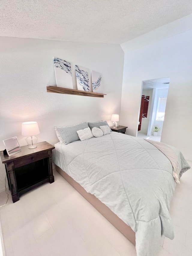 bedroom with a textured ceiling and vaulted ceiling