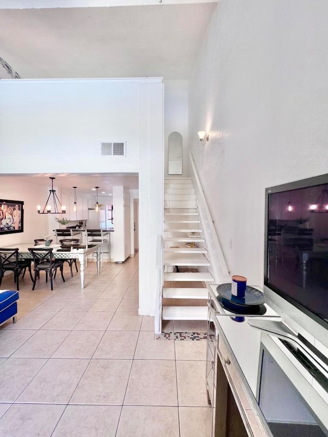 stairway featuring tile patterned floors and a chandelier