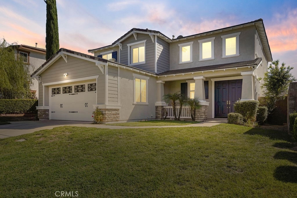 craftsman-style house with a yard, a garage, and covered porch