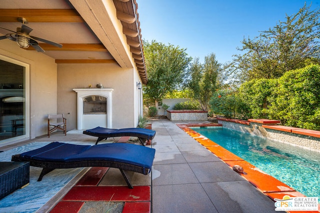 view of swimming pool with pool water feature, ceiling fan, and a patio area