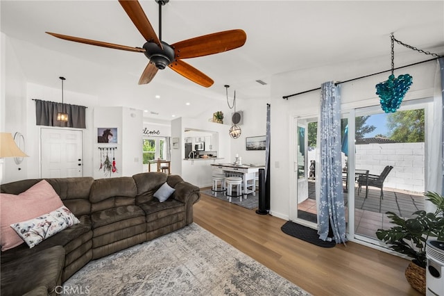 living room with ceiling fan, hardwood / wood-style flooring, and lofted ceiling