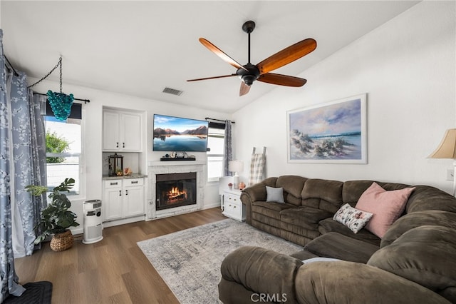 living room featuring vaulted ceiling, ceiling fan, and dark hardwood / wood-style floors