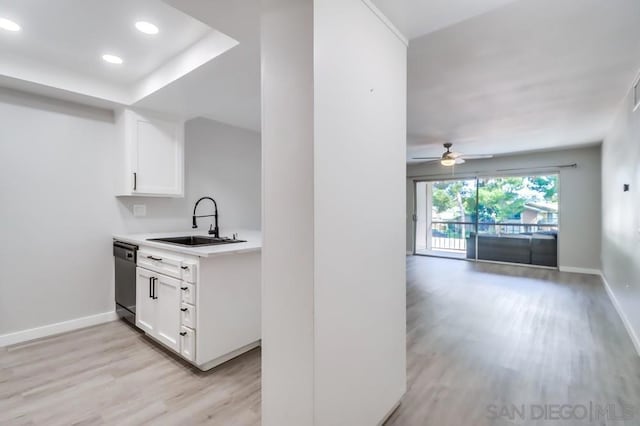 kitchen with stainless steel dishwasher, light hardwood / wood-style floors, white cabinets, and sink