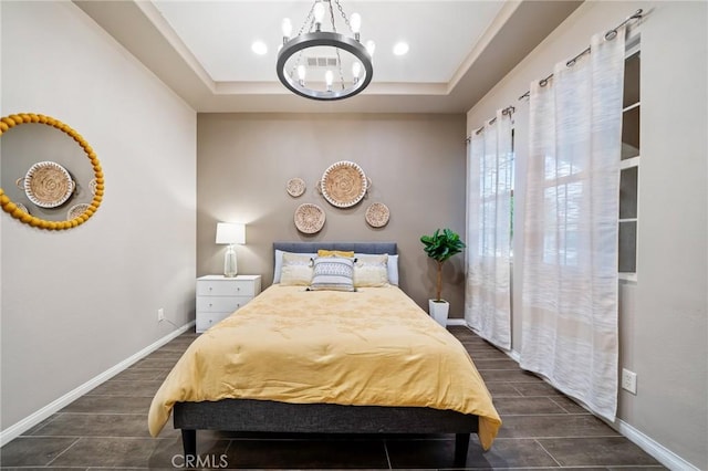 bedroom featuring a notable chandelier, dark hardwood / wood-style floors, and a raised ceiling