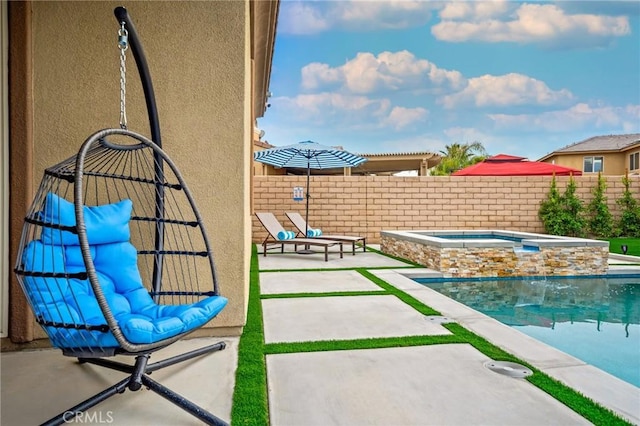 view of swimming pool featuring a patio area and an in ground hot tub