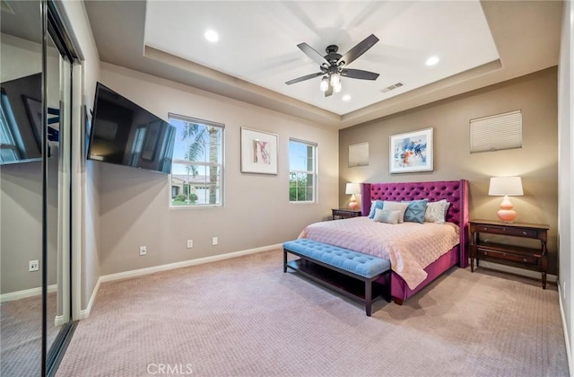 bedroom with carpet flooring, ceiling fan, and a tray ceiling