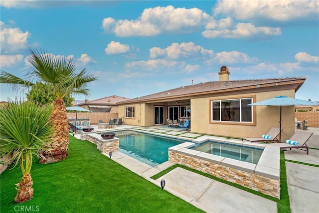 view of pool featuring a lawn, a patio area, and an in ground hot tub