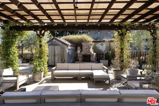 view of patio with a shed, an outdoor living space with a fireplace, and a pergola