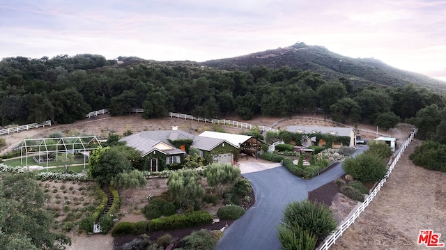 aerial view at dusk featuring a mountain view and a rural view