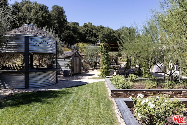 view of yard featuring a gazebo, a storage shed, and a patio