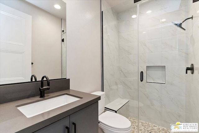 bathroom featuring vanity, toilet, and a shower with door