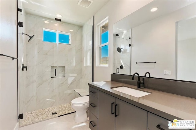 bathroom featuring toilet, tile patterned flooring, vanity, and a shower with door