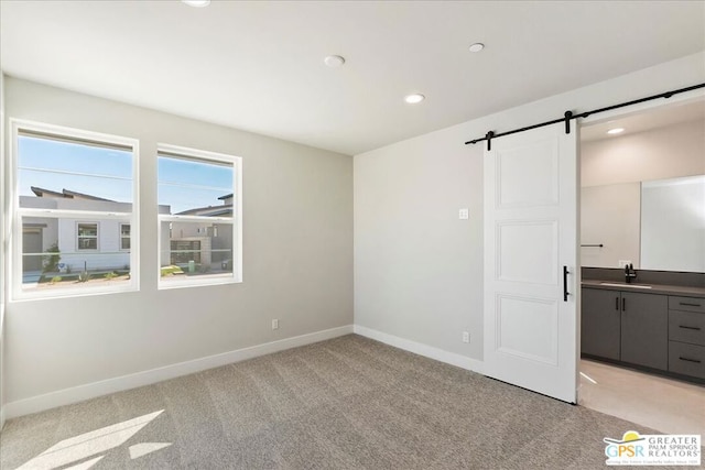 interior space featuring light carpet, sink, and a barn door