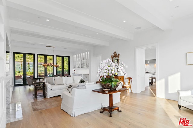 living room featuring light wood-type flooring, beamed ceiling, french doors, and a chandelier