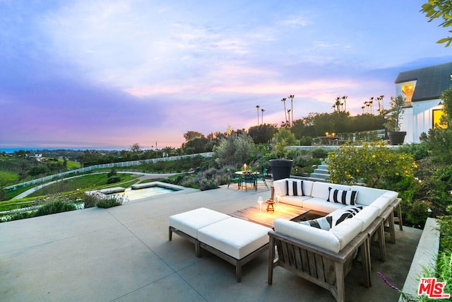 patio terrace at dusk featuring an outdoor hangout area