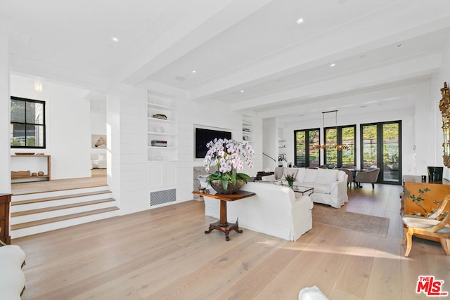 living room featuring light hardwood / wood-style floors, beamed ceiling, built in shelves, and a chandelier